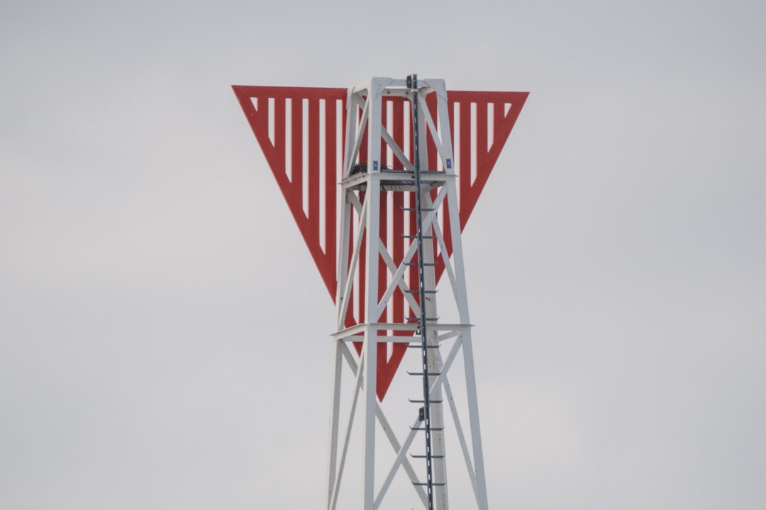 a-red-and-white-triangular-structure-on-a-tower-p9-abse9mx8
